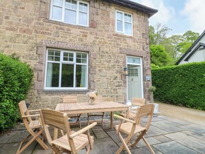 A stone building with a door marked '9', a window, and a table with chairs outside. - Lumford Mill Cottage (Bakewell)