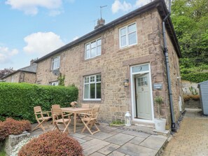 A stone cottage with a front door, a satellite dish, and a sign reading 'Lunford Mill Cottage.' - Lumford Mill Cottage (Bakewell)