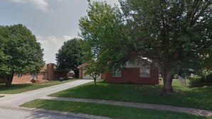 Una calle residencial con casas, aceras y árboles.