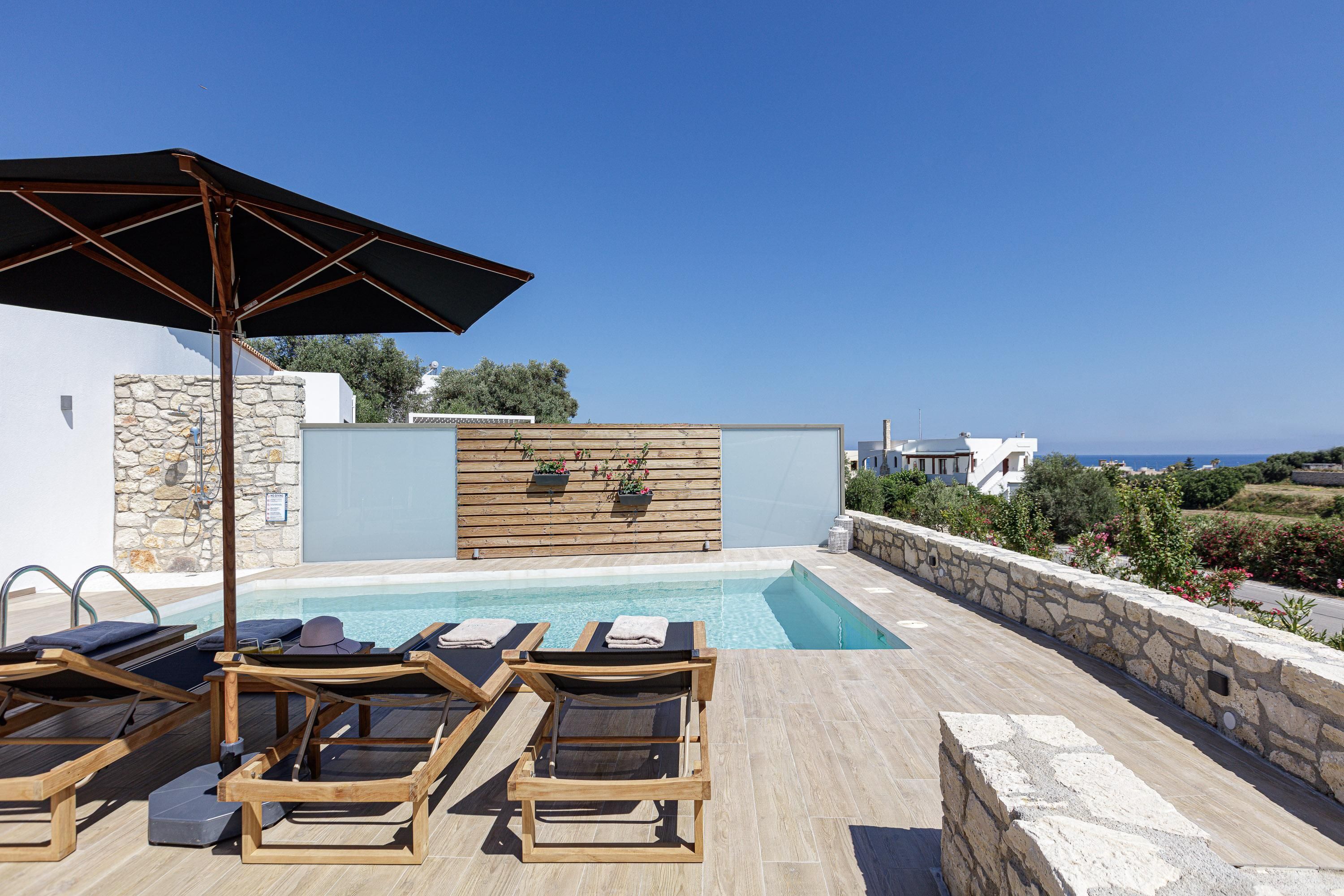 Area piscina con poltrona prendisole, parete in legno con fioriere e vista mare.