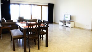Ein Essbereich mit Tisch, Stühlen und einem Fernseher in einem Wohnzimmer.