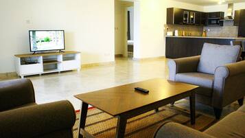 A living room with a TV, sofa, and coffee table.