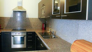 Una cocina con encimeras de granito, electrodomésticos de acero inoxidable y armarios oscuros.