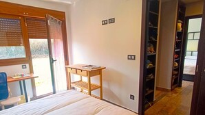 Ein Schlafzimmer mit Bett, Schreibtisch und Kleiderschrank.