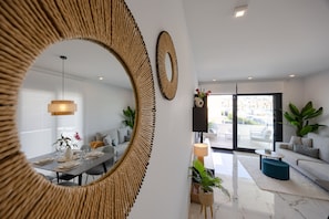 A modern living room with a dining area, large mirrors, and a view to the outside. - Casa Alegria – Oasis of Light, Terrace and Wellness on the Costa Blanca (Orihuela Costa)