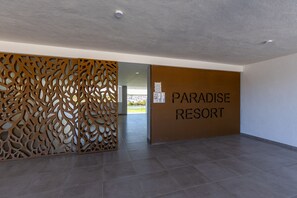 Ein modernes Interieur mit einer dekorativen Holzvertäfelung und einem Schild mit der Aufschrift 'PARADISE RESORT'.