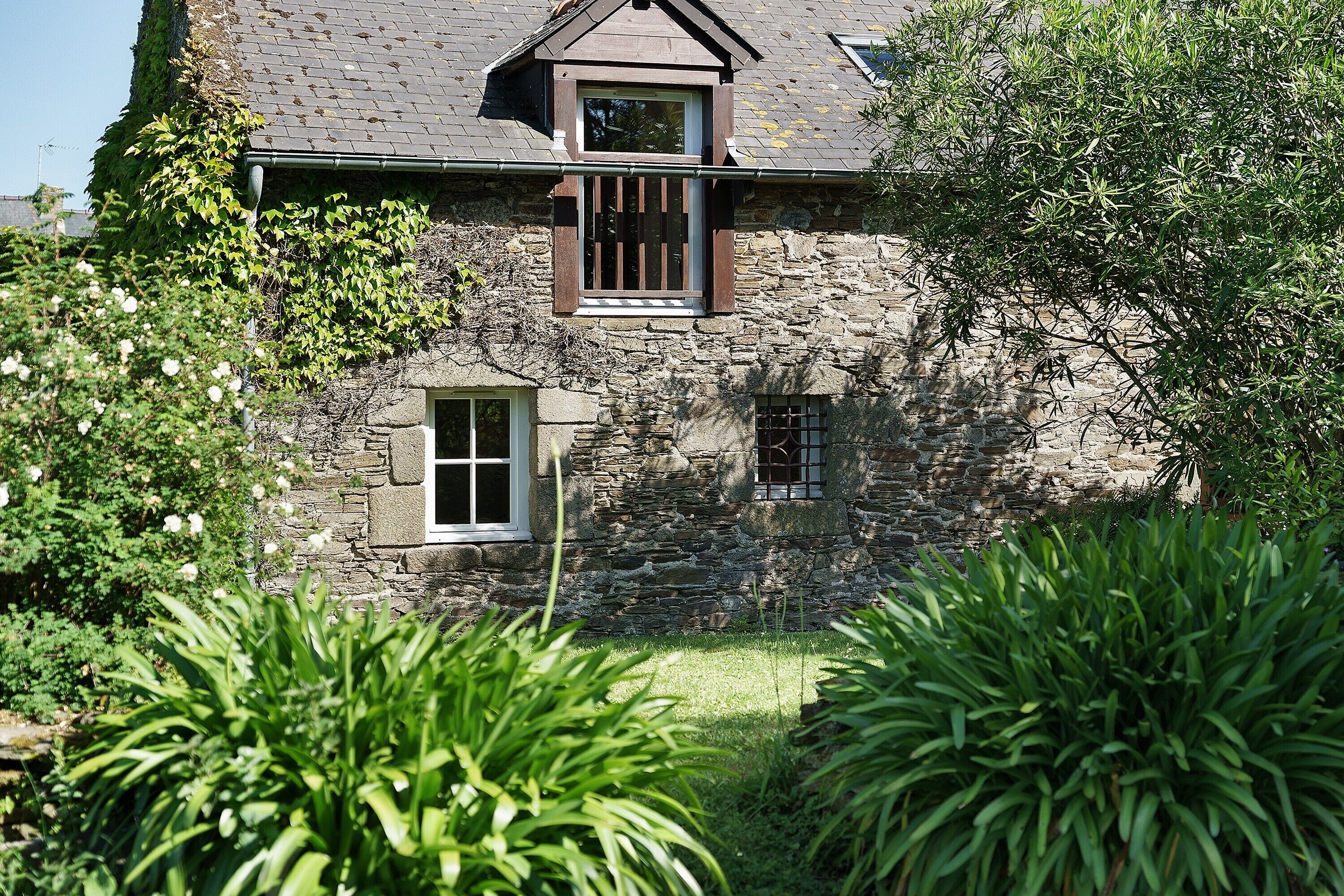 Ein Steinhaus mit einem kleinen Fenster und einem Balkon.