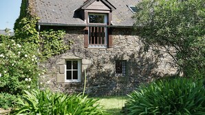A stone building with a small window and a balcony. - Guest Room “Les Hirondelles” with Shared Terrace, Communal Garden and Wi-Fi (Cancale)