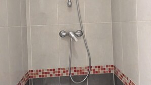 Eine Dusche mit Handbrause und Wandarmatur.