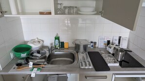 Eine Küche mit Spüle, Herd und verschiedenen Küchenutensilien.