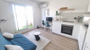 A modern apartment with a living area, kitchenette, and large sliding glass doors to a balcony. - AC studio with balcony in central Arcachon (Arcachon)