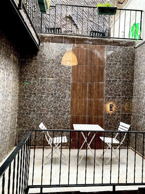 A small outdoor patio with a tiled floor, a wooden door, and a metal railing. - Unique Andcosy Flat Between and Near Taksim and Nişantaşı (Istanbul)