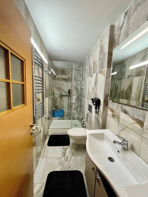 A modern bathroom with a glass shower enclosure, a white sink, and a toilet. - Unique Andcosy Flat Between and Near Taksim and Nişantaşı (Istanbul)