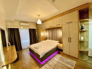 A modern bedroom with a bed, bedside tables, a wardrobe, and a built-in shelf. - Unique Andcosy Flat Between and Near Taksim and Nişantaşı (Istanbul)