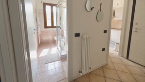 A hallway leading to a bathroom with a toilet, a shower, and a radiator. - Urban Light 1Bedr, 1SofaBed, Central, Free Parking (Forli)