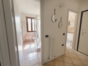 A hallway leading to a bathroom with a toilet, a shower, and a radiator. - Urban Light 1Bedr, 1SofaBed, Central, Free Parking (Forli)