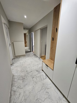 A hallway with marble flooring, white walls, and a wooden bench. - *L'Avant-Première* Near train station, Pompidou and Arena (Metz)
