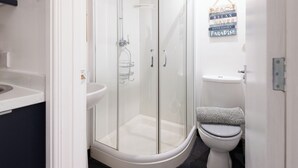 A bathroom with a glass-enclosed shower, a toilet, and a sink. - Guestz at The Wellington (Blackpool)