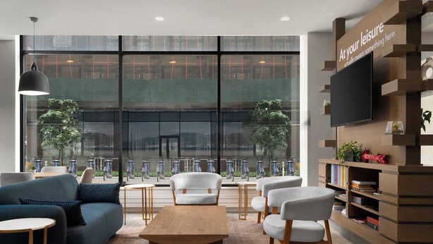 Un espace de détente moderne comprenant un canapé, des fauteuils, une table basse et une bibliothèque.