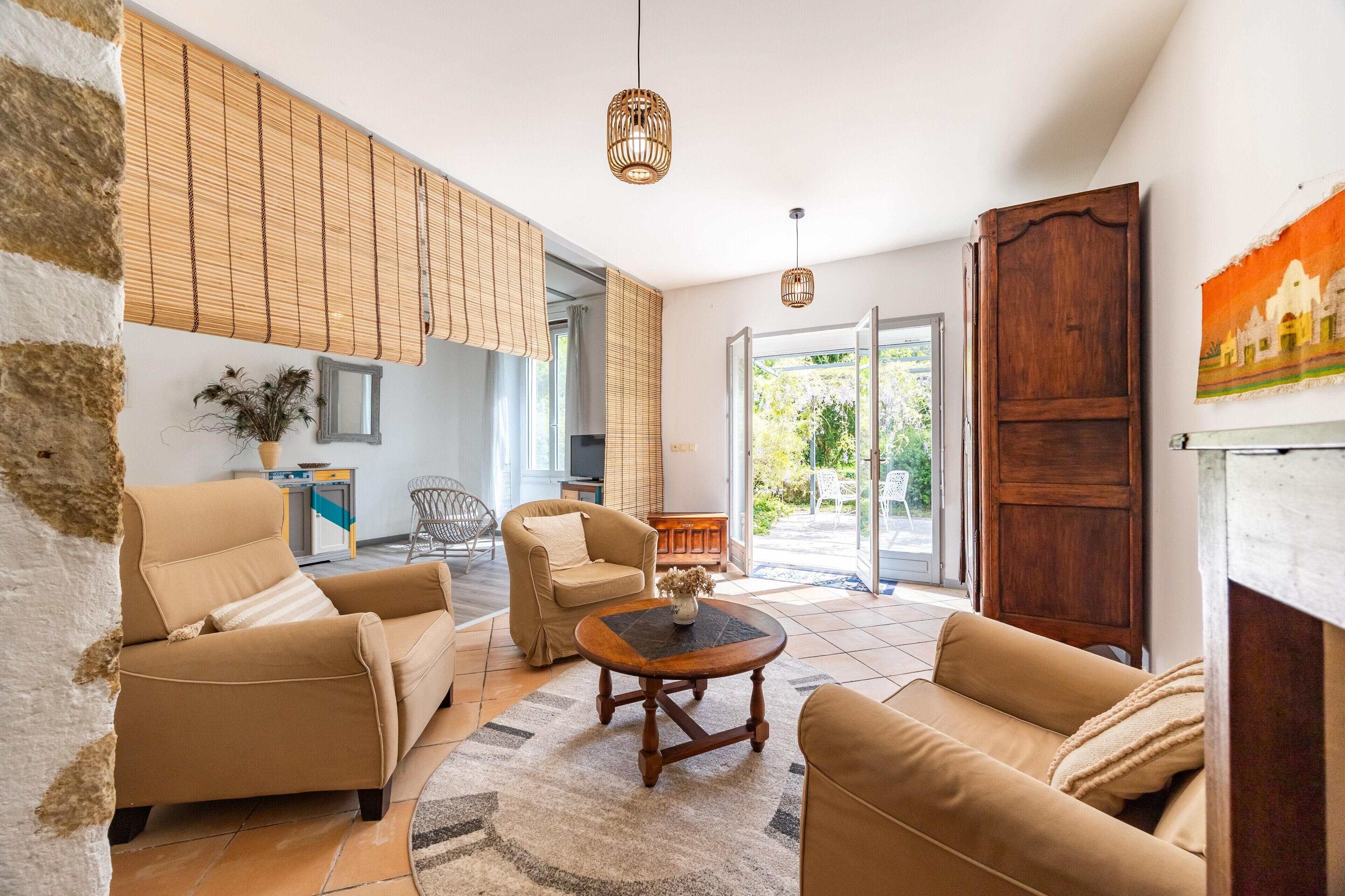 A spacious living area with a sofa set, a coffee table, and a large window providing a view of the outdoors.