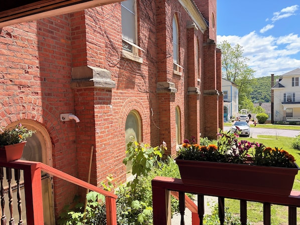 A red brick building with a wooden staircase and potted plants. - Wonderful Ex Pariah House, Wonderful location (Little Falls)