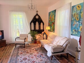 A living room with a sofa, armchair, TV, chandelier, and artwork. - Wonderful Ex Pariah House, Wonderful location (Little Falls)
