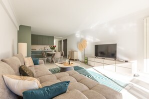 A modern living room with a sectional sofa, a flat-screen TV, and a dining area with chairs and a table. - Ref 705520 in Cannes (Cannes)