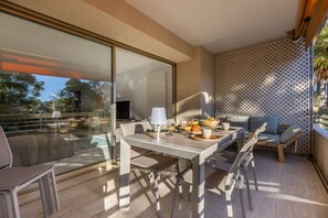 A modern dining area with a glass partition, a dining table set with plates, glasses, and a lamp. - Ref 705520 in Cannes (Cannes)