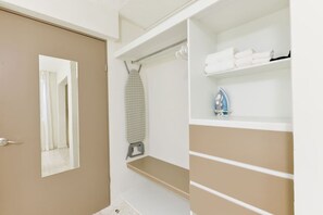 A closet with hanging space, shelves, and a door.