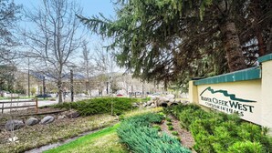 A landscaped area with a sign for 'Beverly Creek West Condominiums.' - Pool, Hot Tub, Complimentary Shuttle to Slopes, Great location! (Avon)