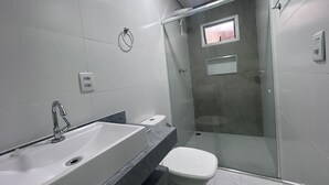 Un baño moderno con ducha, inodoro y lavabo.