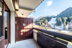 Ein Balkon mit Holzbalkon und Blick auf eine verschneite Berglandschaft.