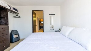 A bedroom with a bed, dresser, heater, and a mirror. - 1 King, 3 Twin bed, Pool & 2 parking | 3BR2br 7ppl (Monterrey)