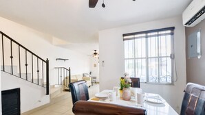A dining area with a table set for four, a staircase, and a window with blinds. - 1 King, 3 Twin bed, Pool & 2 parking | 3BR2br 7ppl (Monterrey)