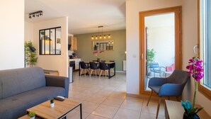 Una sala de estar moderna con un sofá, una mesa de centro y un comedor con sillas y una mesa.