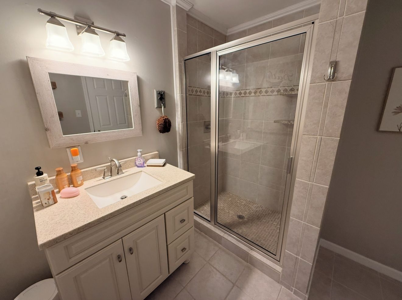 Une salle de bain avec un lavabo, un miroir et une douche.