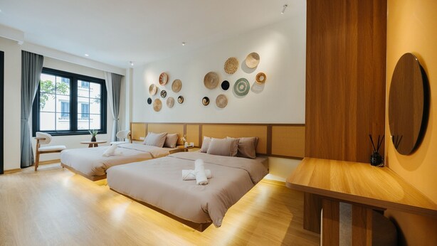 A modern hotel room with two beds, a wooden headboard, a large window, and a wall decorated with woven baskets. - Moc Vien Homestay Train Street (Hanoi)