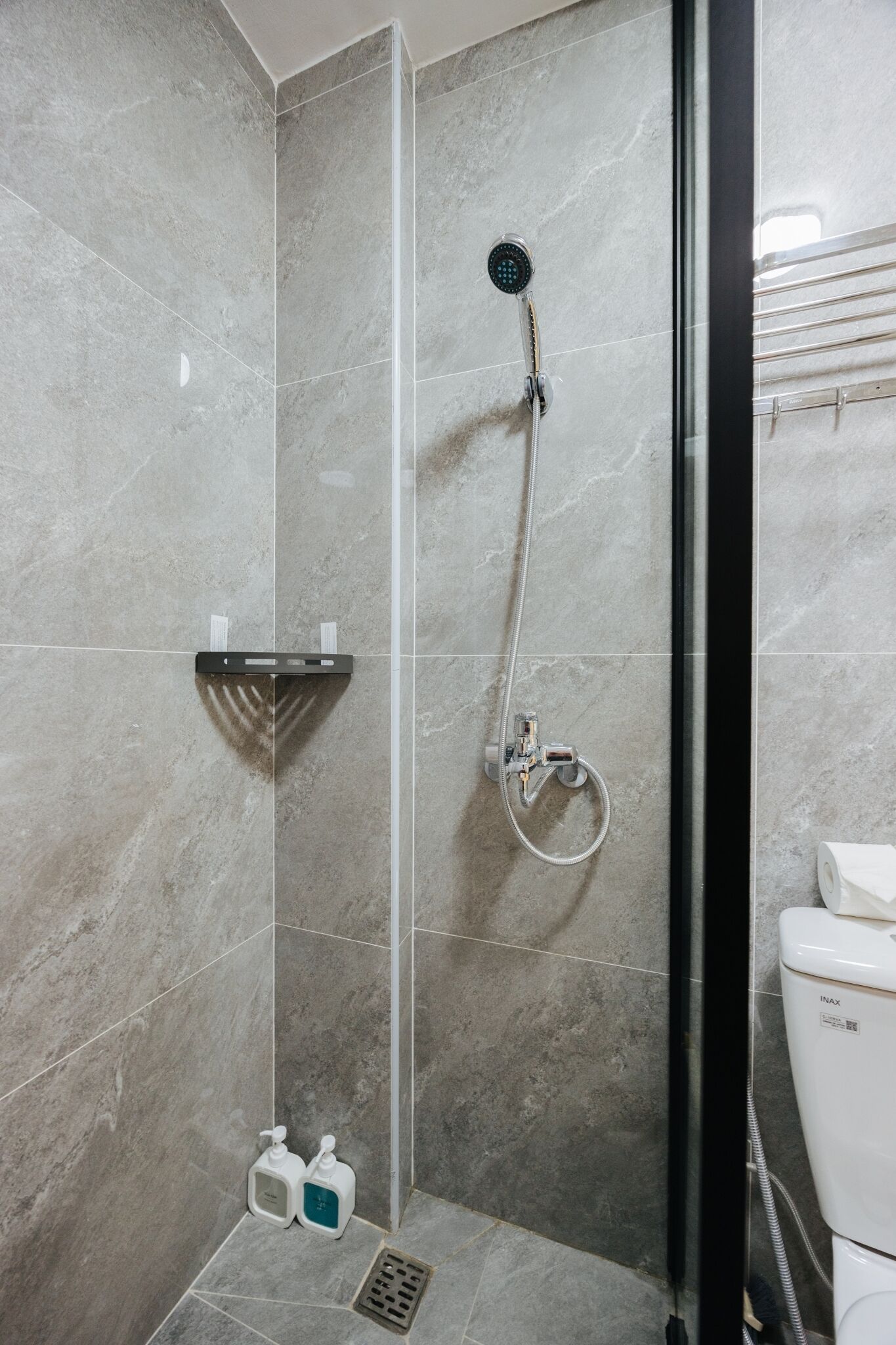 Une salle de bain avec une douche, des toilettes et un lavabo.