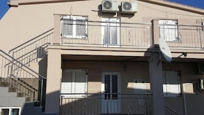 A two-story building with a balcony, air conditioning units, and a satellite dish. - Americana Karlobag Apartments (Karlobag)