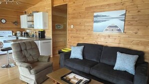 A wooden interior with a sofa, armchair, and a coffee table.