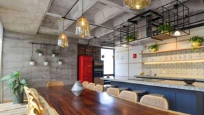 Una cocina moderna con una mesa de comedor de madera, plantas colgantes y un salpicadero de azulejos.