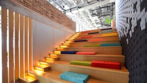 Una escalera con peldaños iluminados y cojines de colores.