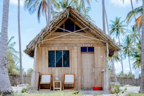 A wooden structure with a thatched roof, labeled 'KAMBA,' featuring two chairs and a window. - Quiet Beachfront Hideaway - Mafia Island - 2355 (Mafia Island)