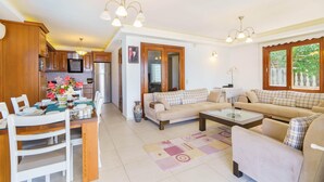 A spacious living area with a dining table, sofas, and a kitchen in the background. - Villa Kuluhana With 3 Bedrooms and 3 Bathrooms (Kaş)