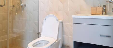 Ein modernes Badezimmer mit Toilette, Dusche und Waschtisch.