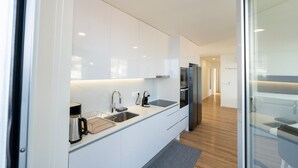 Eine moderne Küche mit weißen Schränken, Edelstahlgeräten und Holzboden.