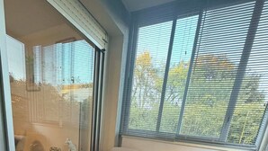 Ein modernes Wohnzimmer mit Glastür zum Balkon, einem runden Couchtisch und einer Couch mit Kissen.