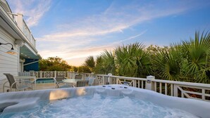 A hot tub with a view of a house and palm trees.