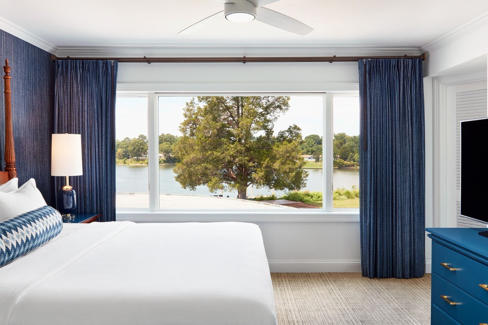 Drift off beside wide windows framing tranquil lake scenery.