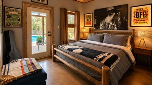 Ein Schlafzimmer mit einem großen Bett, einem Deckenventilator und gerahmten Postern an den Wänden.